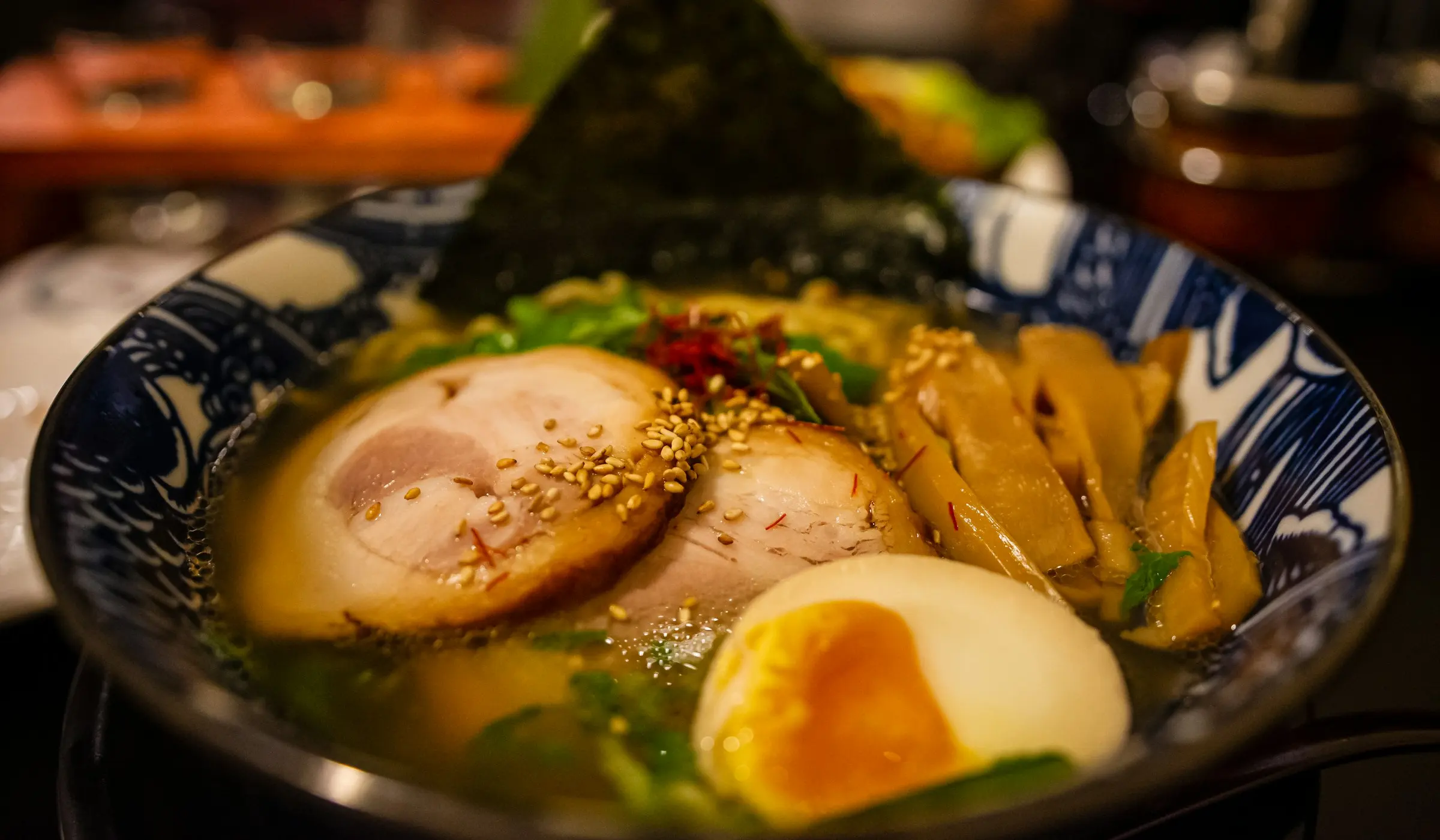 A bowl of ramen with broth, noodles and spring onion
